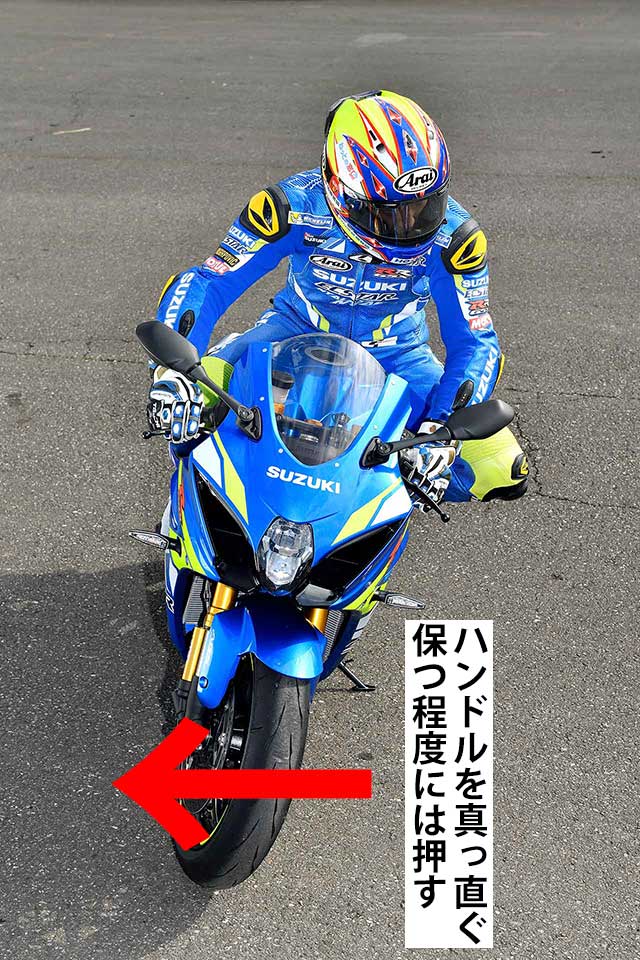 フロントタイヤの切れ込みを抑え、寝かせて旋回力を高めるためにイン側のハンドルを押しています。「押す」というより「ステアリングヘッドをまっすぐに保つ」イメージ。難易度が高いので安易にマネしないでください。