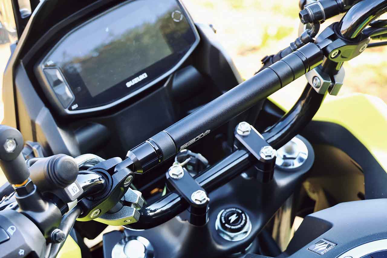 ZETA RACING「バーライズキット（5,060円）」はハンドルバーの高さを上げることを可能にする（14mm、19mm（写真）がラインナップ）。ZETA RACING「アジャスタブルマウントバー ハンドルブレースタイプ（5,500円）はスマホホルダーなどを装着するマルチバーとしてだけでなく、ハンドルバー剛性向上にも寄与する可能性があり、ダート走行向きなのだ