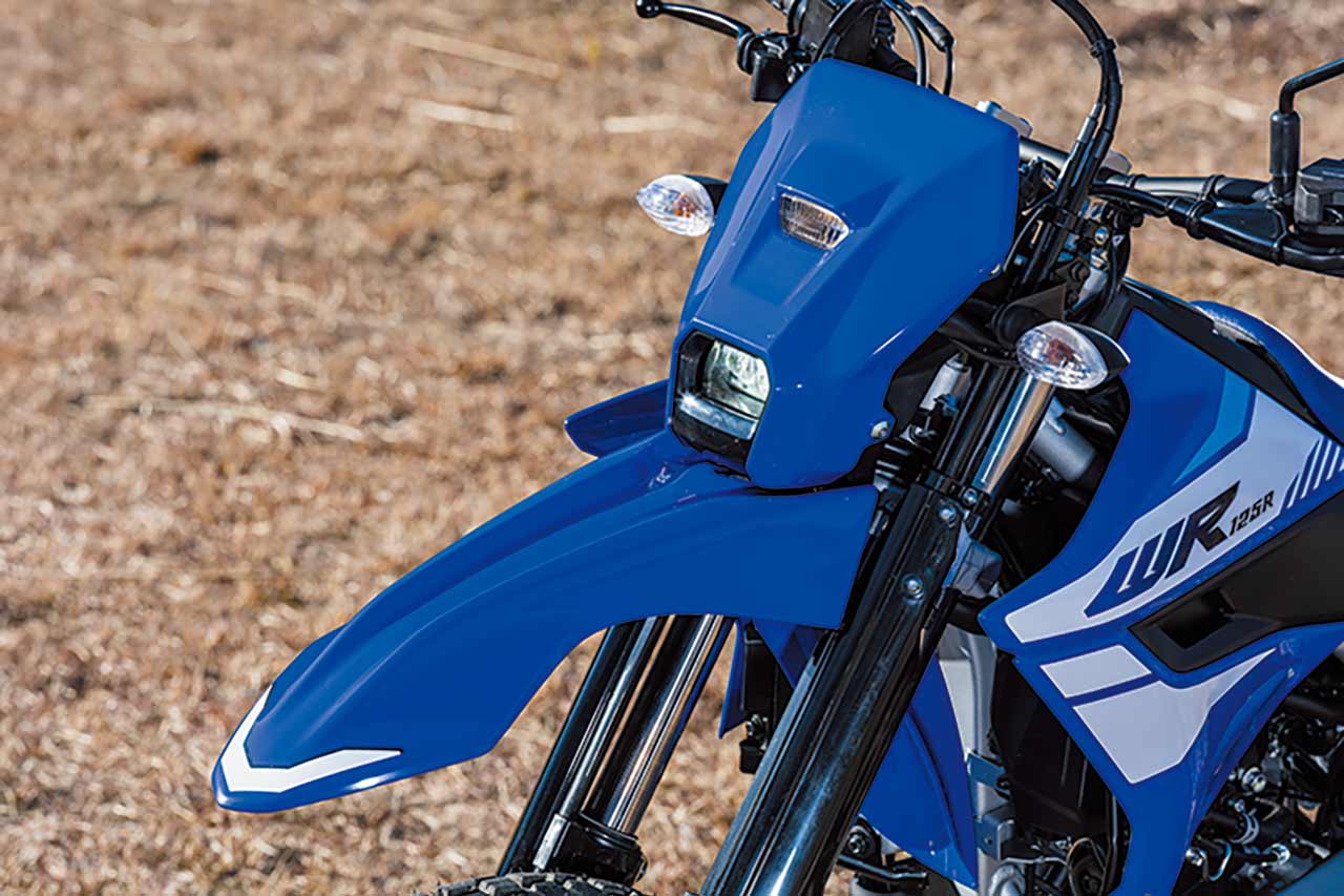 コンパクトなLEDヘッドライトは、小型で薄い小径レンズモジュールを用いている。ユニークな縦目2灯は単に2つのライトを1つに見せるような手法ではなく、機能を追求したレイアウトだ。メインライトを低く車体に寄せ、ポジションランプは極限までコンパクトに配置。メインライトをインテーク内に配置された脇役のように演出することで、タイトな顔回りを作り上げているという